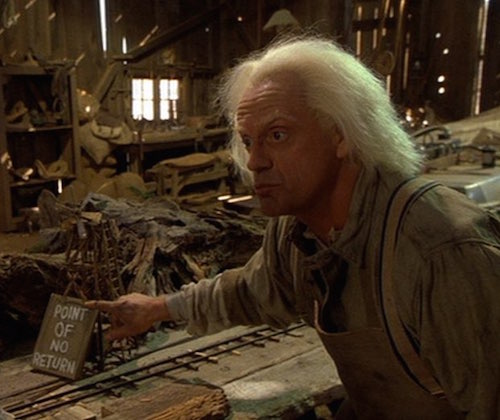 Doc Brown pointing at a sign in a miniature model that says "Point of no return"